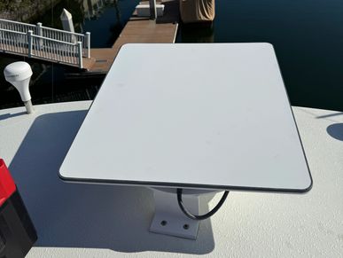 A white rectangular antenna mounted on a boat deck under sunlight.