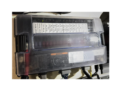 Close-up of an electrical fuse box with labeled circuits under a transparent cover.
