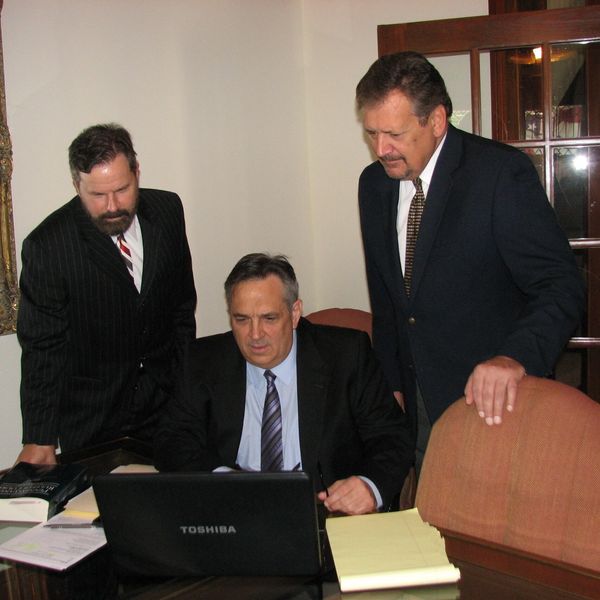 Three people are discussing in a laptop