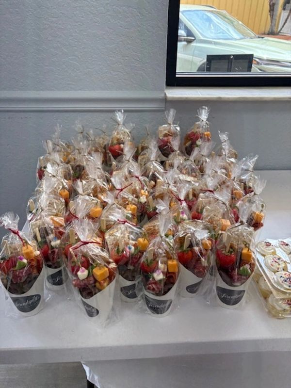 Wrapped snack cups with various treats on a table.