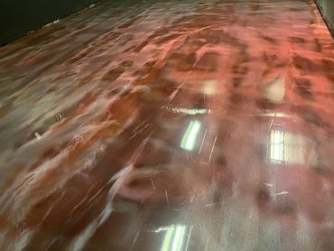 Glossy reddish floor reflecting overhead lights in a dimly lit space.