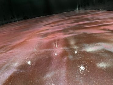 A shiny, marbled floor with pink and brown swirls in a dark room.