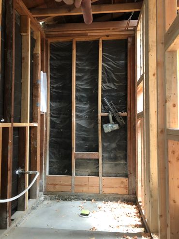 Uninstalled bathroom with exposed wood walls.