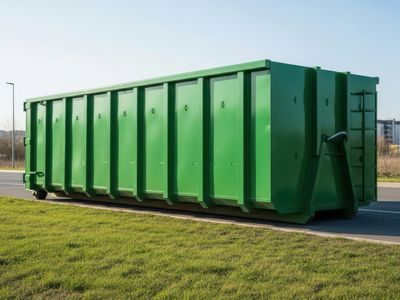 Large green industrial container placed outdoors on a sunny day.