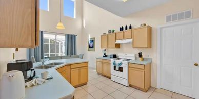 Bright kitchen with beige cabinets and white appliances.