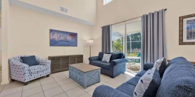 Bright living room with blue sofas and natural light.