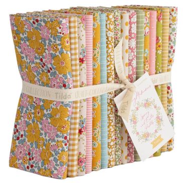Bundle of colorful floral and patterned fabric squares tied with a cream ribbon.