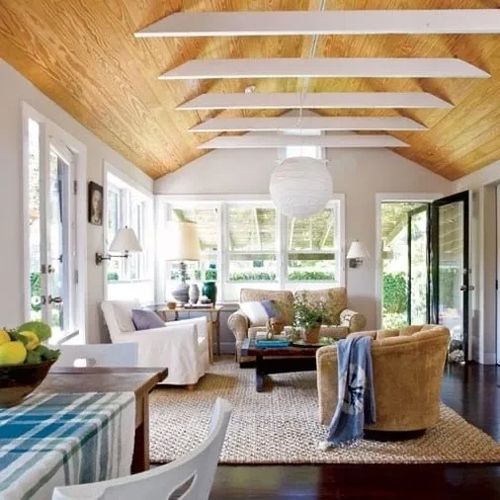 Bright living room with wooden ceiling and cozy seating.