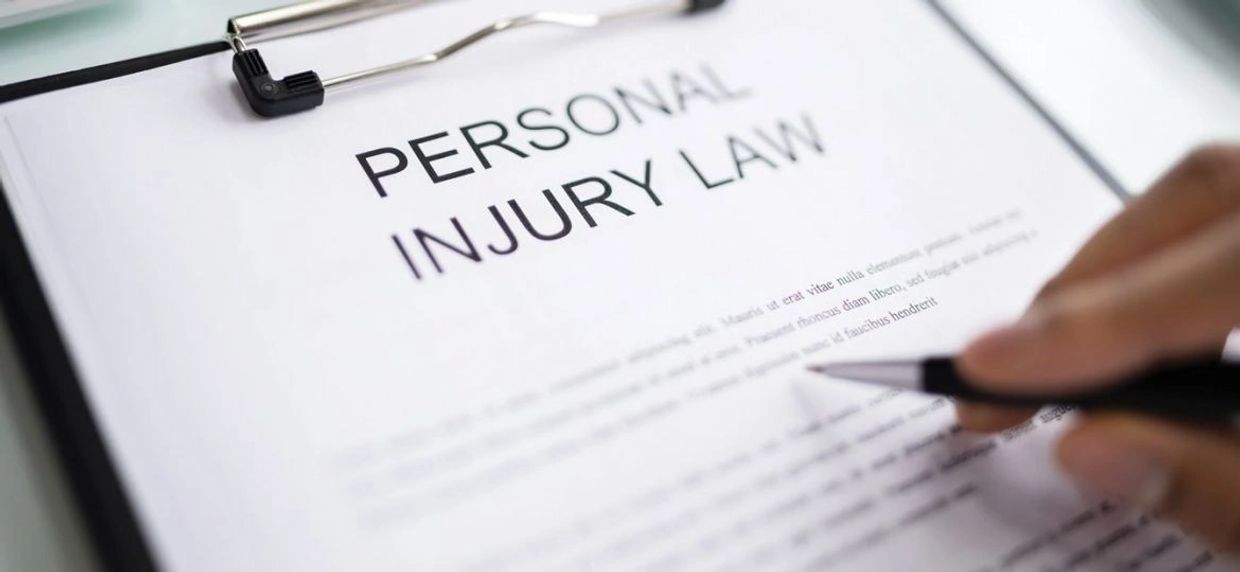 Document titled 'Personal Injury Law' being reviewed with a pen.