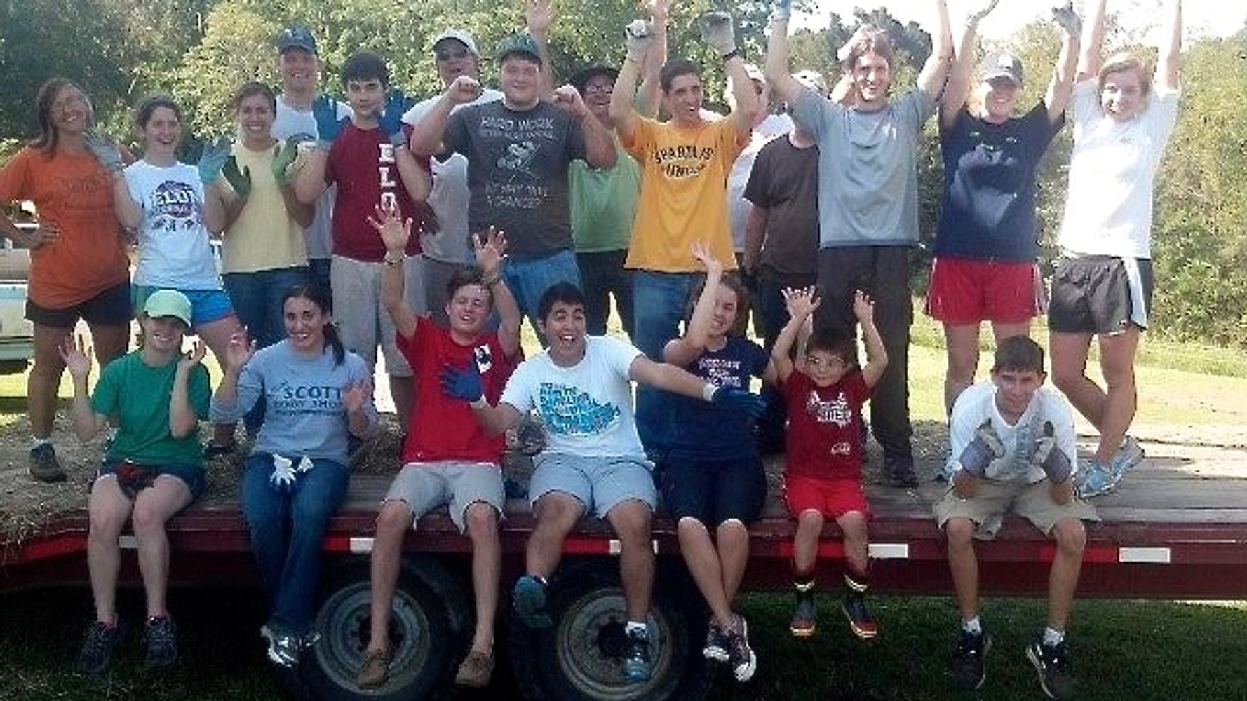 Many Hands loading hay into the barn