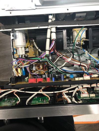 Wall oven with all the covers removed showing wiring