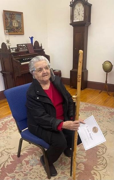 Lois Bulger holding the stick honoring her as the oldest Vassalboro resident
