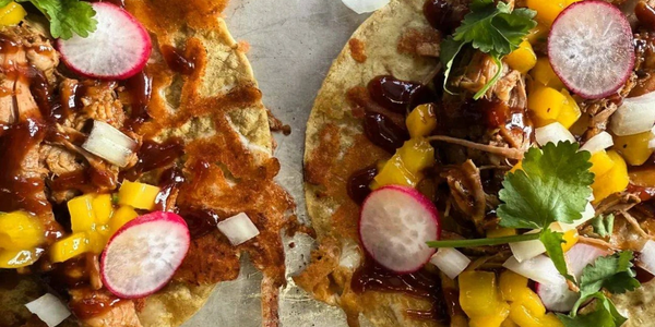 Selection of street food including bao buns, chicken satay skewers, prawn laksa broth