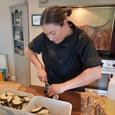 Female private chef preparing aubergine for private dining in a customer's kitchen