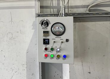 Industrial control panel with various buttons and a pressure gauge labeled 'Monkey Works'.