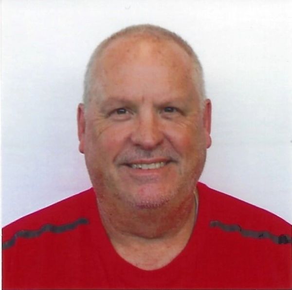 Smiling middle-aged man in red shirt.