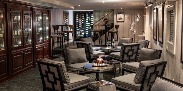 Elegant lounge with modern seating and wine storage.
