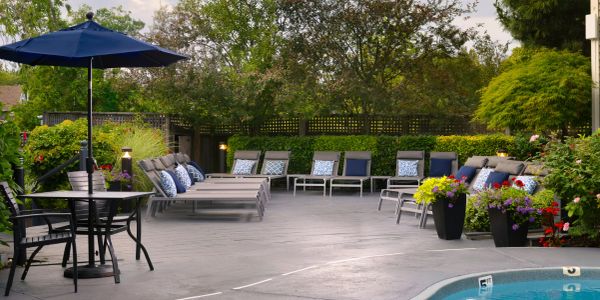 A cozy outdoor patio area with chairs and a pool.