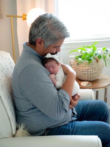 Newborn dad holding baby in nursery for a lifestyle newborn photoshoot in Austin, Texas.