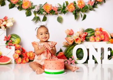 Girl poses in a watermelon cake smash setup for her photography session in Austin, Texas. 