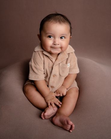 Baby boy smiles for his milestone photo session. 