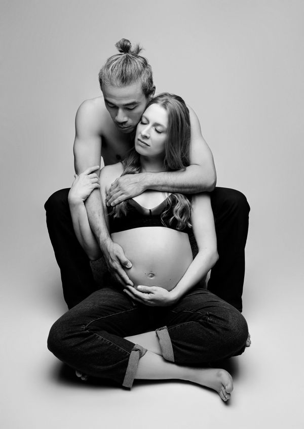 Expecting couple embrace during their session with an Austin, Texas maternity photographer.