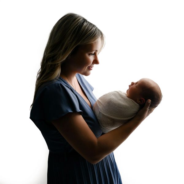 Mom holds baby during a newborn photoshoot in an Austin, Texas photography studio.