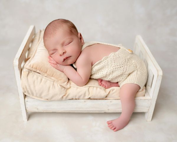 Baby sleeps on bed during his newborn photoshoot with Austin newborn photographer.