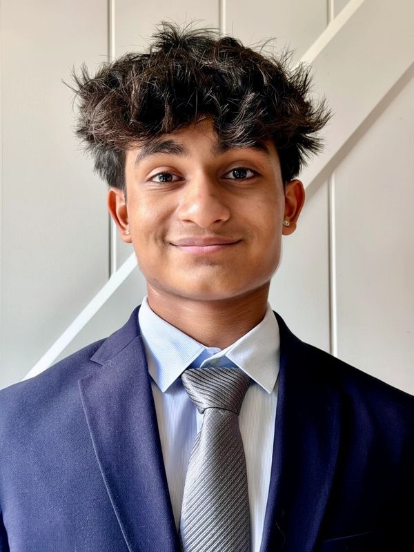 Young man in a suit and tie smiling at the camera.