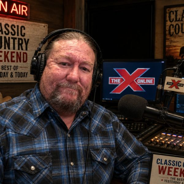 Radio host in a studio with headphones and microphone.