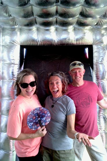 3 adults friends posing for a Photo Booth picture.