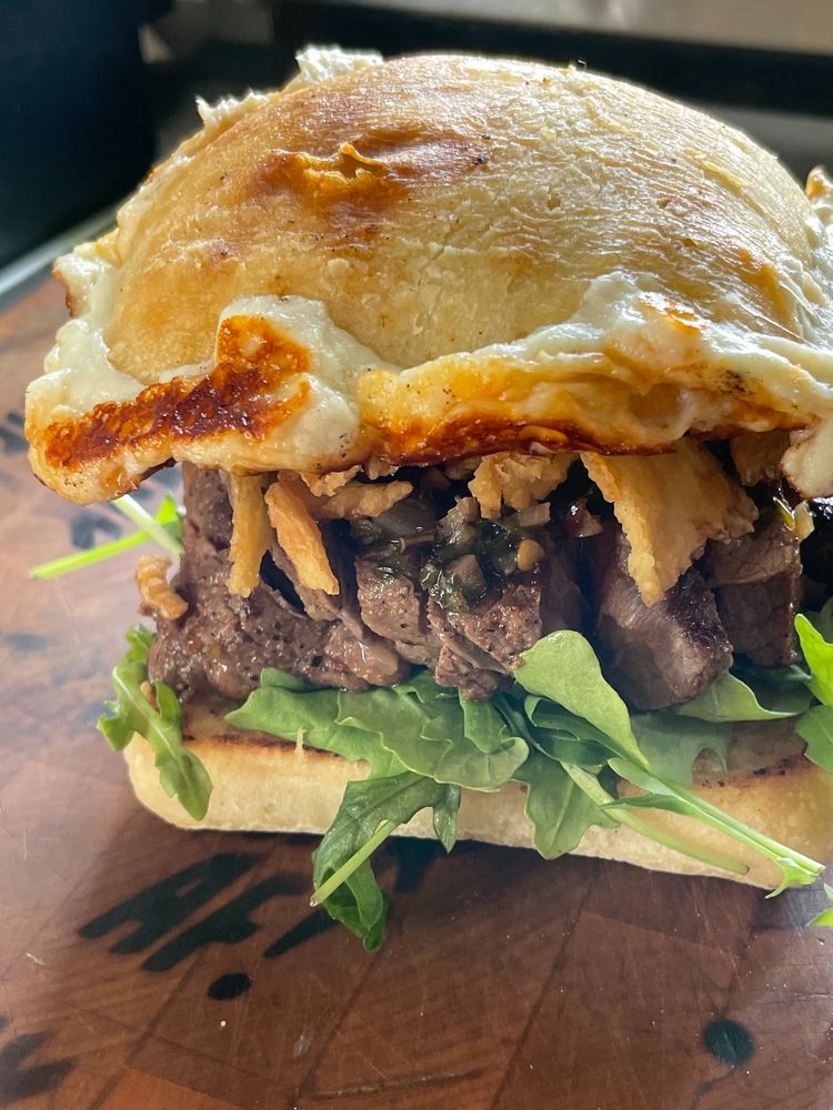 Gourmet steak sandwich, with steak,cheese,arugula,ciabata bread,crispy onions, chimi churri sauce