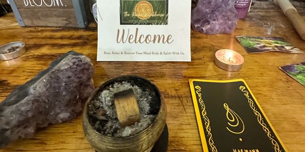 A spiritual altar with crystals, sage, and cards on a wooden table.