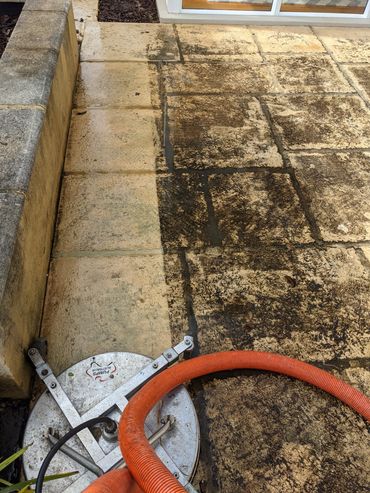 Pressure washing reveals clean tiles beneath dirt and grime.