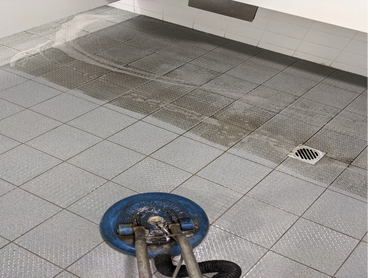 Floor cleaning machine revealing a clean tiled surface.