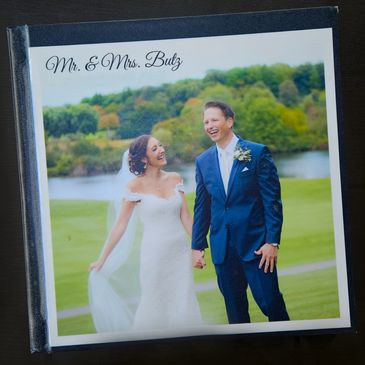 Wedding album cover featuring a joyful bride and groom outdoors.