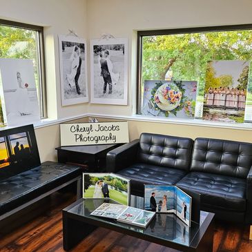 Cozy photography studio corner displaying wedding photos and albums.