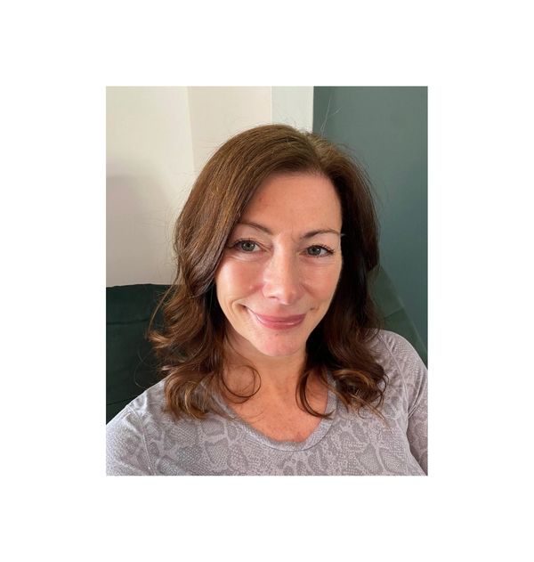 Woman with light brown hair smiling at the camera.