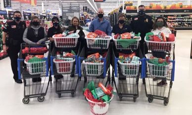 DFF volunteers and FLPD with grocery carts full of groceries packaged up for families in need.