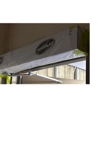 Newly installed door closer wrapped in protective plastic.