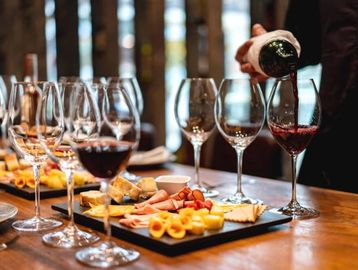 Wine being poured with appetizers on the table.