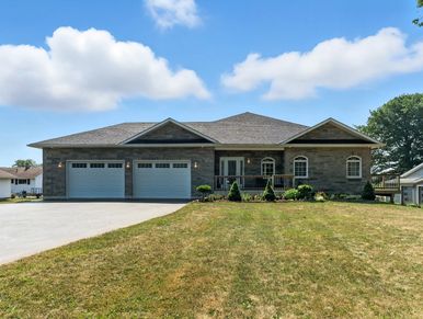 A modern single-story house with a large driveway and well-kept lawn.