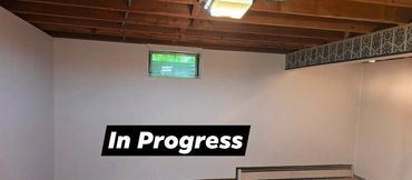 Basement walls during painting, with the original In Progress label visible.