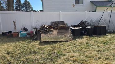 Dismantled shed and trampoline materials gathered during the yard cleanup project.