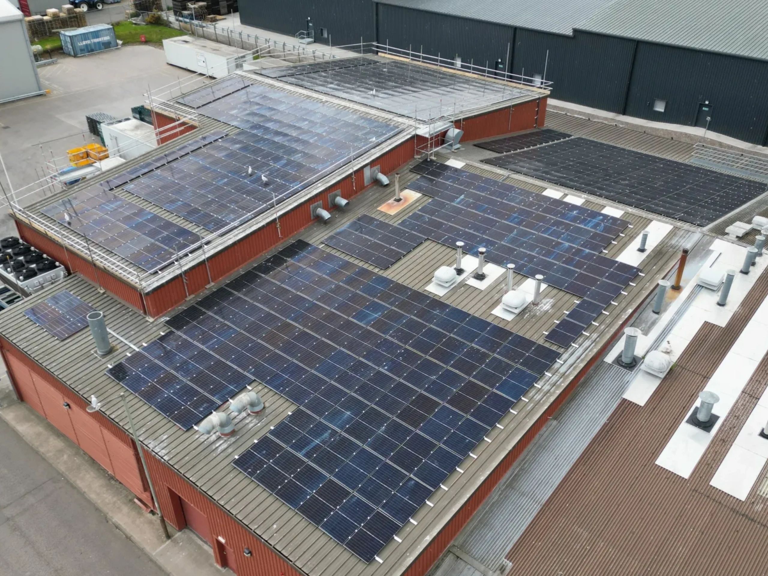 Solar panels installed on the rooftop of an industrial building.