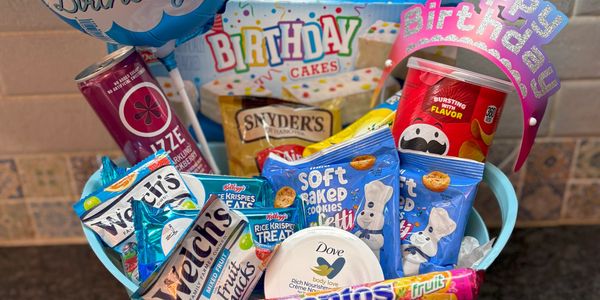 Birthday gift basket with snacks, a balloon, and a birthday tiara.