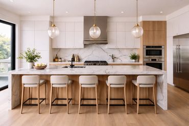 Modern kitchen with marble island and wooden stools under pendant lights.