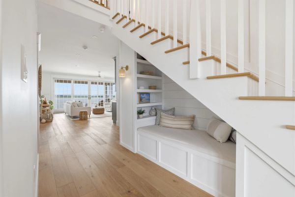 Bright and airy coastal home interior with staircase seating nook.