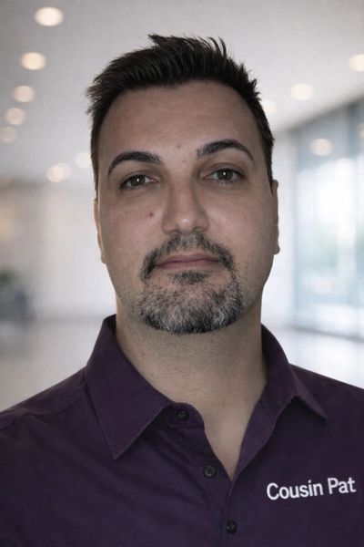 Dr. Patrick Argiro: Cousin Pat wearing a purple shirt with 'Cousin Pat' embroidered on it.