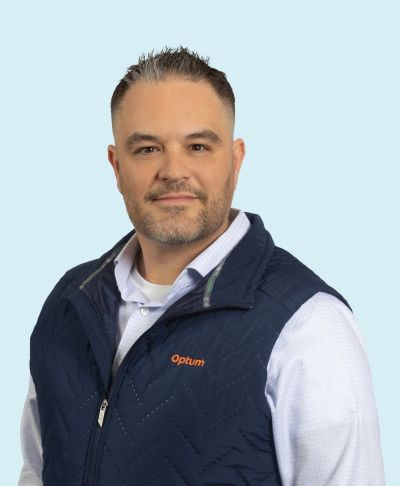 Man wearing a navy blue vest and white shirt.